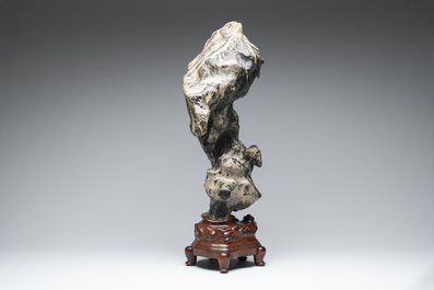 A Chinese green Lingbi stone scholar's rock on wooden stand, 20th C.