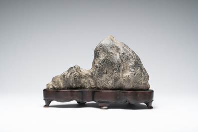 A Chinese Lingbi stone scholar's rock on wooden stand, 20th C.