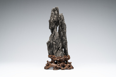 A Chinese ying stone scholar's rock on wooden stand, 20th C.