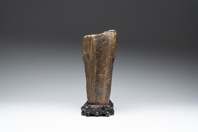 A Chinese petrified wood scholar's rock on wooden stand, 17/18th C.