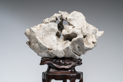 A Chinese Taihu stone scholar's rock on wooden stand, 20th C.
