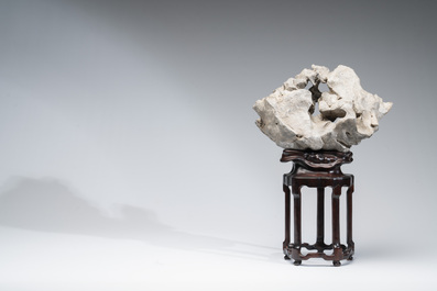 A Chinese Taihu stone scholar's rock on wooden stand, 20th C.