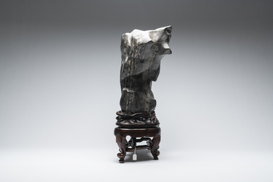 A large Chinese Lingbi stone scholar's rock on wooden stand, 19/20th C.
