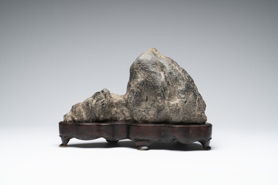A Chinese Lingbi stone scholar's rock on wooden stand, 20th C.