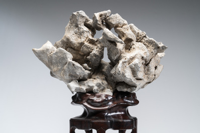 A Chinese Taihu stone scholar's rock on wooden stand, 20th C.