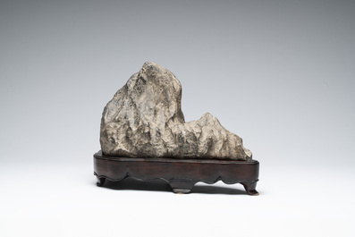 A Chinese Lingbi stone scholar's rock on wooden stand, 20th C.