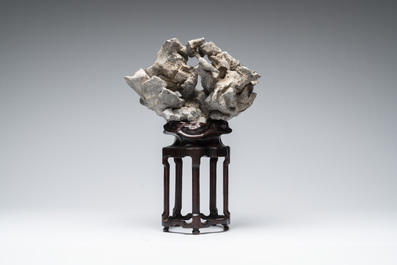 A Chinese Taihu stone scholar's rock on wooden stand, 20th C.