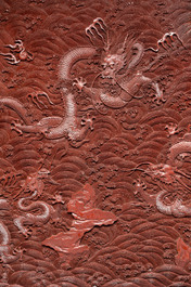 A rectangular Chinese carved red lacquer 'dragon' table screen, later wooden stand, Qianlong