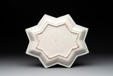 A rare blue and white Dutch Delft star-shaped dish with travellers in a landscape, early 18th C.