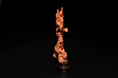 A Chinese pink-orange coral group of a goddess of spring, a wise man and children in a pine tree, 19/20th C.