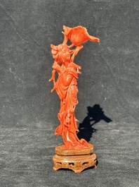 A Chinese red coral figure of a standing lady holding a flower, 19/20th C.