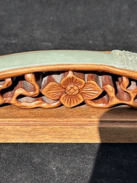 A Chinese pale celadon jade 'double happiness' hairpin on a ruyi-shaped wooden stand, 19th C.