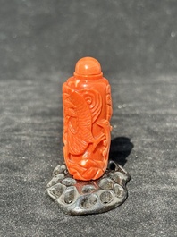 A Chinese carved red coral 'dragon' snuff bottle on wooden stand, 19/20th C.