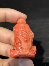 A Chinese carved red coral 'dragon' snuff bottle on wooden stand, 19/20th C.