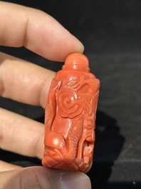 A Chinese carved red coral 'dragon' snuff bottle on wooden stand, 19/20th C.