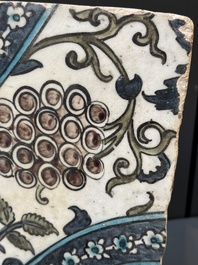 A Syrian Damascus Iznik-style tile with grape and flower scrolls, early 17th C.