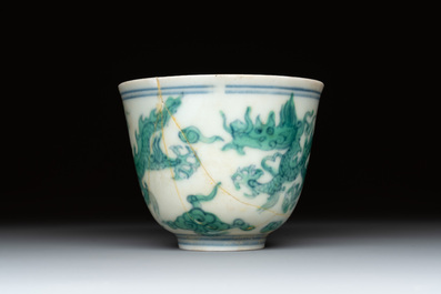 A Chinese gilt-decorated blue and white 'lotus scroll' square bowl, a saucer and a doucai 'dragon' cup, Daoguang mark and of the period