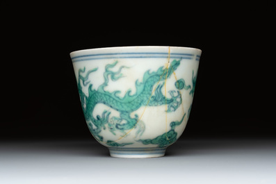 A Chinese gilt-decorated blue and white 'lotus scroll' square bowl, a saucer and a doucai 'dragon' cup, Daoguang mark and of the period