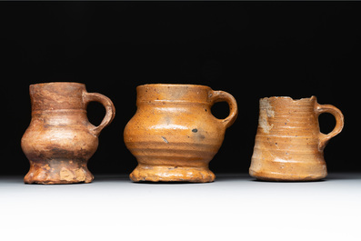 Eight stoneware jugs and mugs, and a glazed pottery vessel, Germany and The Netherlands, 16/17th C.