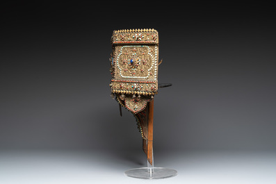 A Nepalese gilt copper console inlaid with glass, precious stones and red coral, 19th C.