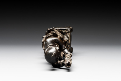 A Chinese bronze incense holder of a boy standing on a lotus, Ming