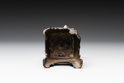 A Chinese bronze incense holder of a boy standing on a lotus, Ming