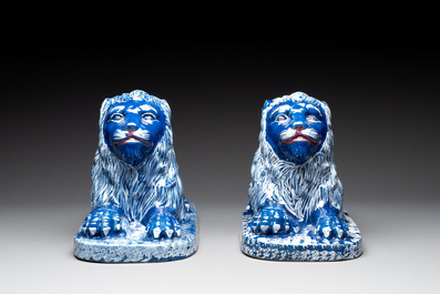 A pair of white-decorated blue-ground faience models of reclining lions, Nevers, 18th C.