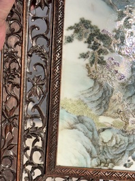 A large Chinese carved wooden table screen with a fine famille rose 'landscape' plaque, 19th C.