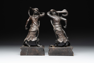 A pair of Chinese bronze guardians on stands, 17/18th C.