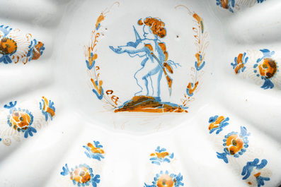 A yellow, blue and white Dutch Delftware dish with a putto playing the violin, Delft or Haarlem, dated 1642