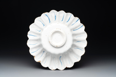 A yellow, blue and white Dutch Delftware dish with a putto playing the violin, Delft or Haarlem, dated 1642