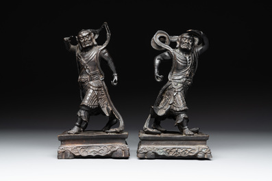 A pair of Chinese bronze guardians on stands, 17/18th C.