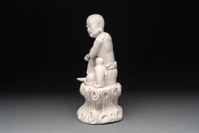 A Chinese Dehua blanc de Chine group of a seated Luohan with a monkey, 20th C.