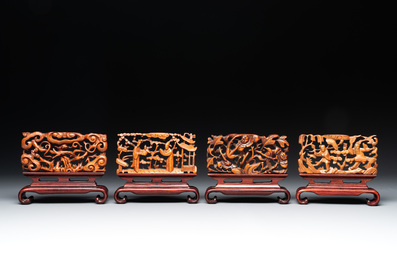 A Chinese octagonal gilt-lacquered wooden stand and four wooden carvings on stands, 19th C.