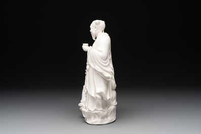 A Chinese Dehua blanc de Chine group of a man and a seated boy on a lion, 20th C.