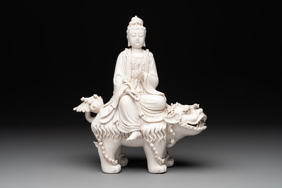 A Chinese Dehua blanc de Chine Guanyin with a ruyi sceptre seated on a Buddhist lion, 20th C.