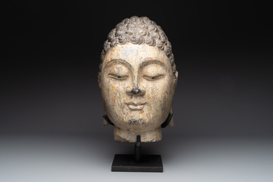 A large Chinese stone head of Buddha with traces of gilding and polychromy, Ming