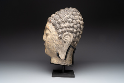 A large Chinese stone head of Buddha with traces of gilding and polychromy, Ming