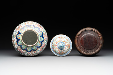 A pair of Chinese famille rose covered vases with figural design and wooden stands, 19th C.