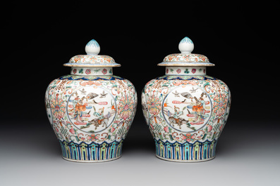 A pair of Chinese famille rose covered vases with figural design and wooden stands, 19th C.