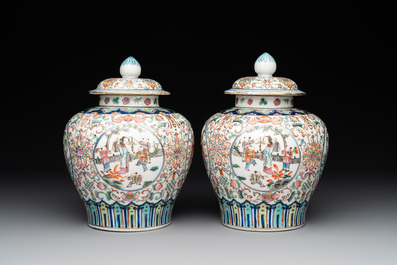A pair of Chinese famille rose covered vases with figural design and wooden stands, 19th C.