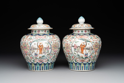 A pair of Chinese famille rose covered vases with figural design and wooden stands, 19th C.