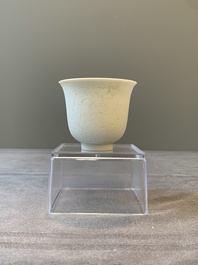 A Chinese white-glazed biscuit 'dragon' cup, Kangxi mark, 19th C.