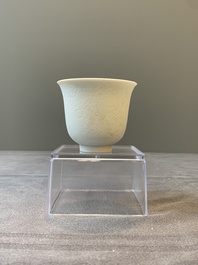 A Chinese white-glazed biscuit 'dragon' cup, Kangxi mark, 19th C.