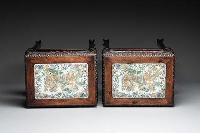 A pair of Chinese famille verte 'narrative' plaques mounted in hardwood tables, 19th C.