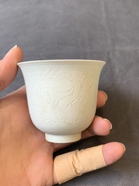 A Chinese white-glazed biscuit 'dragon' cup, Kangxi mark, 19th C.