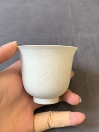 A Chinese white-glazed biscuit 'dragon' cup, Kangxi mark, 19th C.