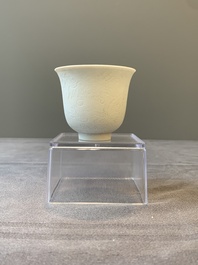 A Chinese white-glazed biscuit 'dragon' cup, Kangxi mark, 19th C.