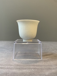 A Chinese white-glazed biscuit 'dragon' cup, Kangxi mark, 19th C.