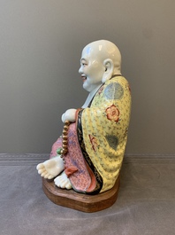 A large Chinese famille rose Milefo Buddha on wooden stand, 20th C.